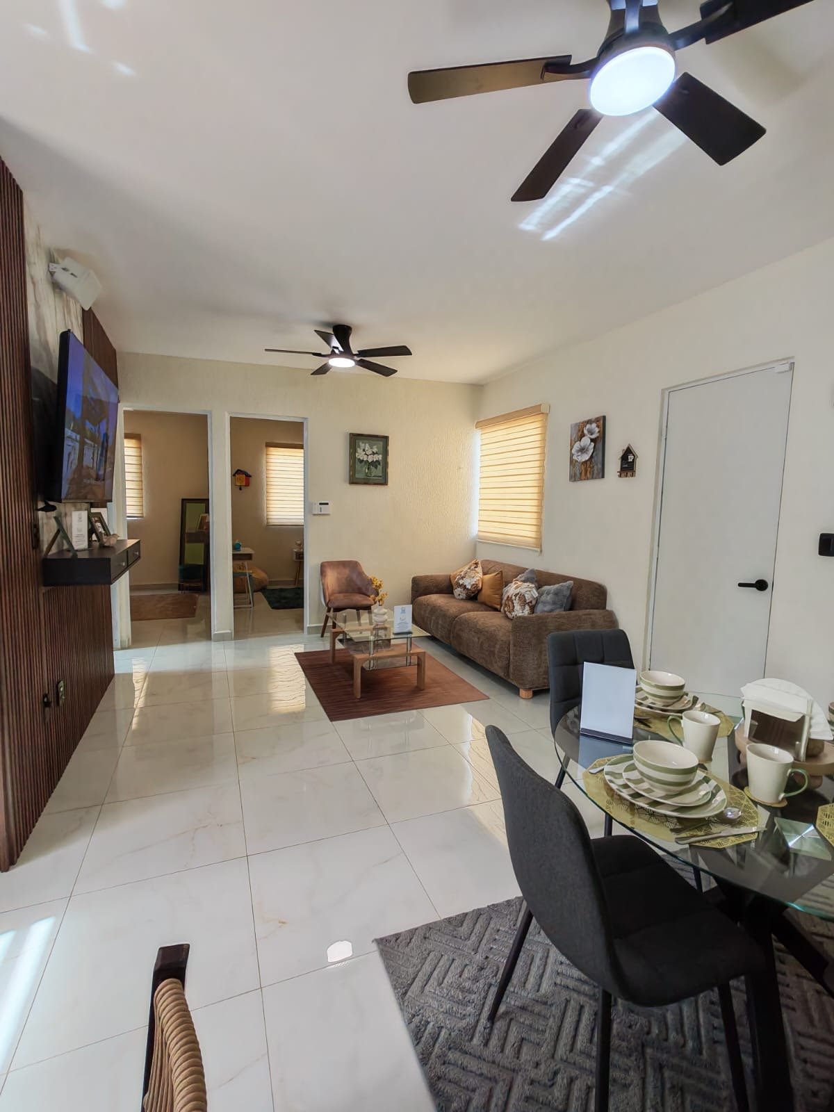 Sala y comedor de concepto abierto con sala, mesa de comedor y acceso a las recámaras
